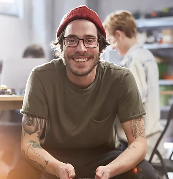 man with tattoos and hat and glasses