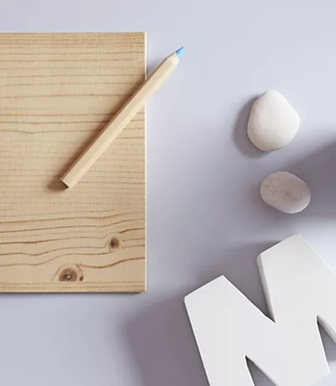 pencil wood pebbles and letter M
