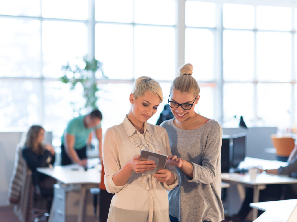 Business Women Using Digital Tablet in Busy Office